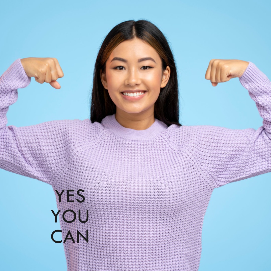 A motivated woman in a purple sweater flexing her arms with the words "YES YOU CAN" displayed, symbolizing the achievement of short-term goals.